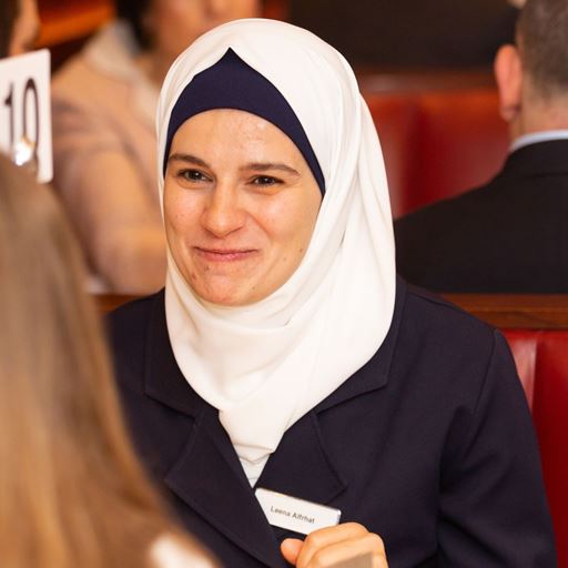 Profile picture of former student Leena Alfrhat smiling at a person she is speaking to