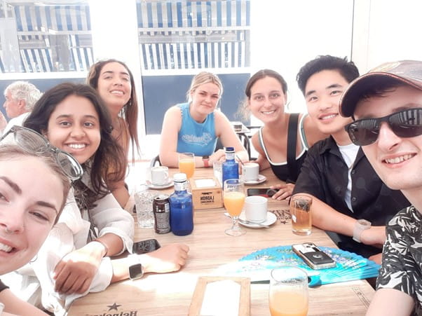 a group of students sitting around a table smiling