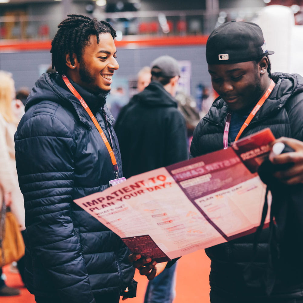 Two people looking at a map in the Sports Arena at an Open Day