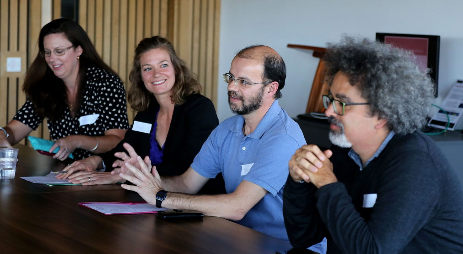 Renee Luthra and Carlos Gramegna sat at a table in a board room, giving a presentation.