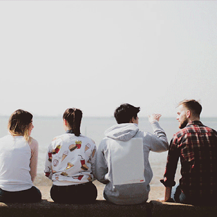 4 people sitting on a wall looking out to sea in southend
