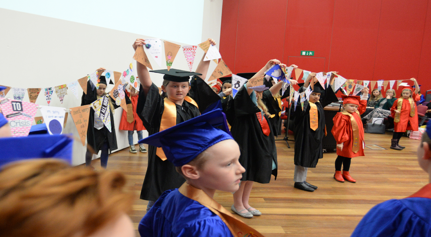 Primary school children holding up bunting they have created 