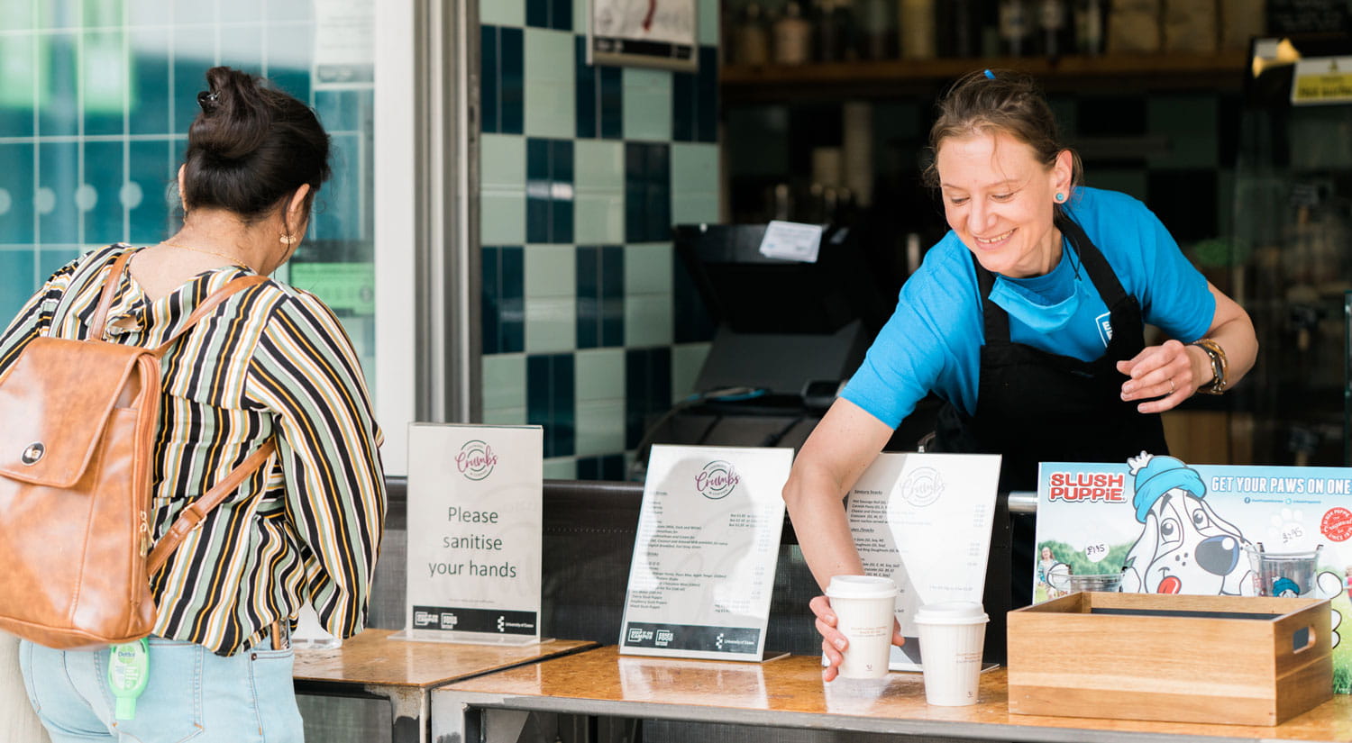 Colleagues in Crumbs coffee shop serving customers on Colchester Campus