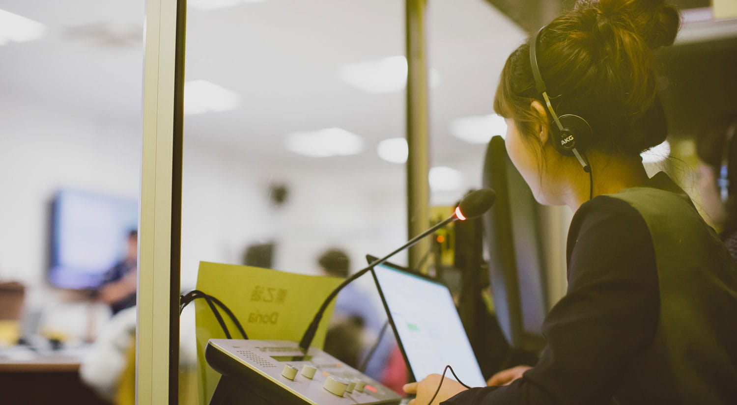 Student working in the translation lab with headphones on)