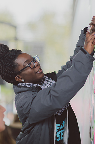 Student on campus near large information board 