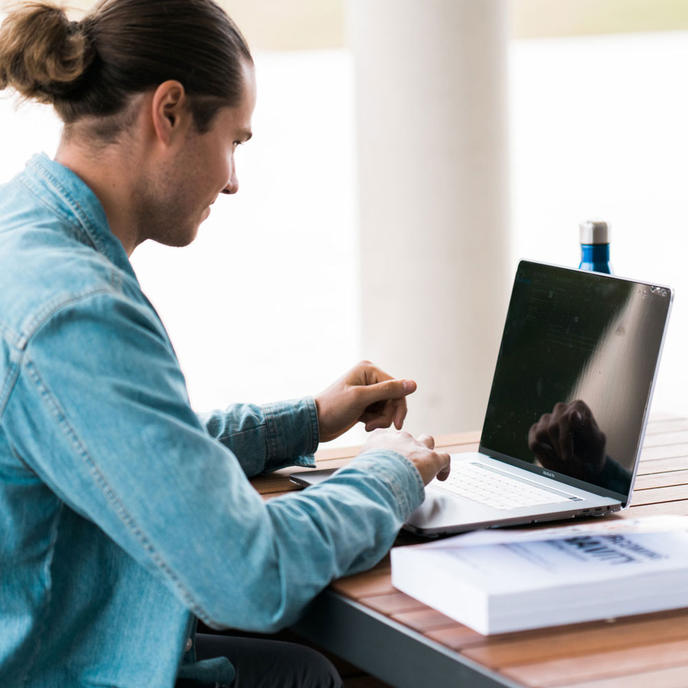 Student looking at their laptop screen at a desk