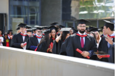 Essex graduates wait in line in their graduation robes