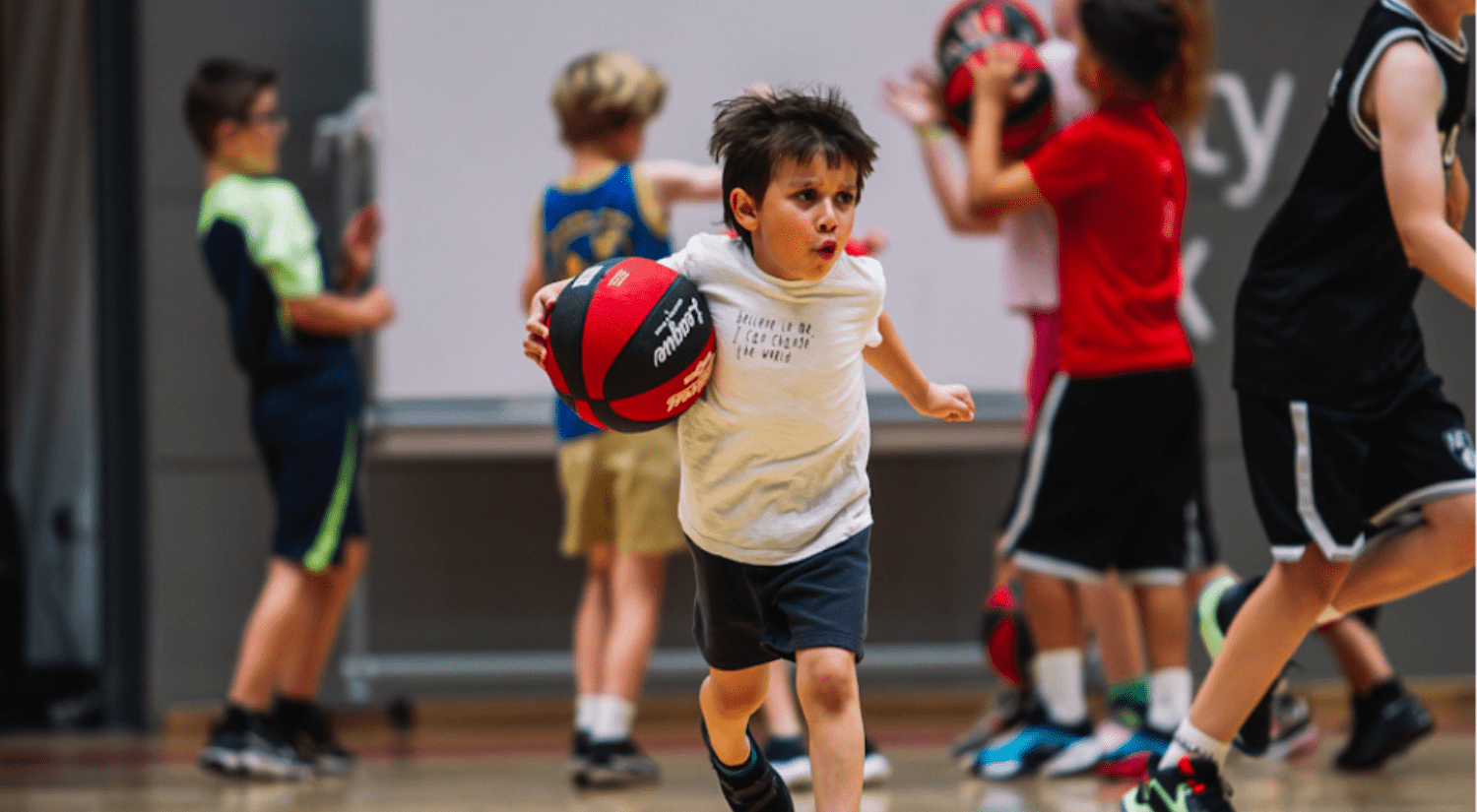 Junior playing basketball indoors