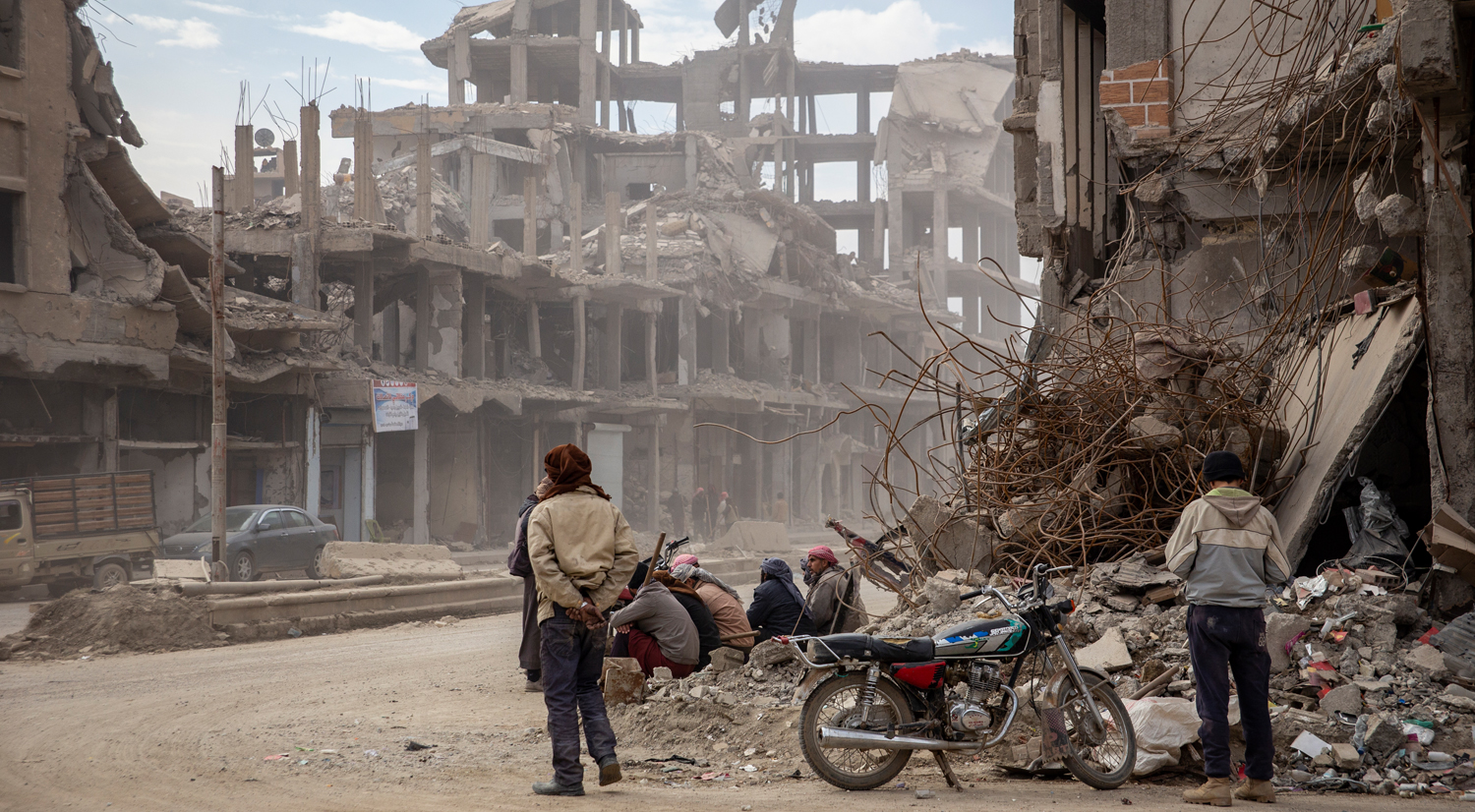 Men wait by the side of the road for casual labour in Raqqa, Syria.