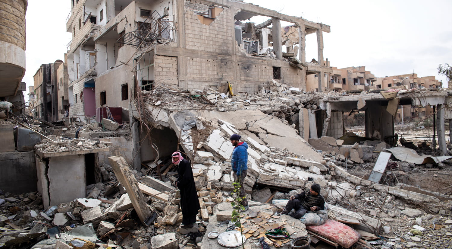 Men in the rubble of Raqqa, Syria.