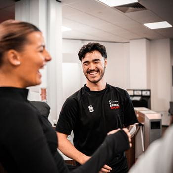 An Essex Staff Sports Member talking in the gym to a student 
