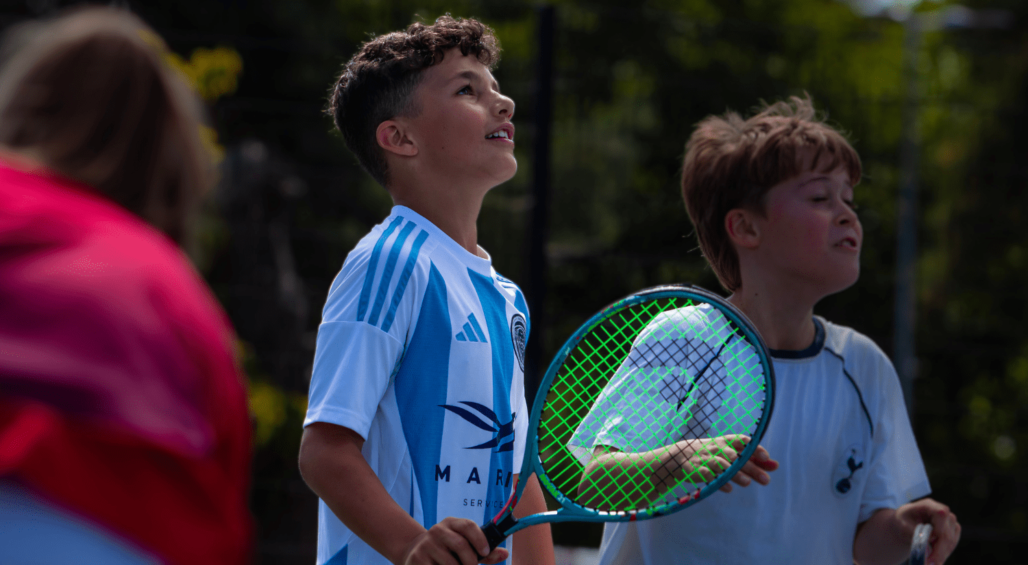 Junior playing tennis outside