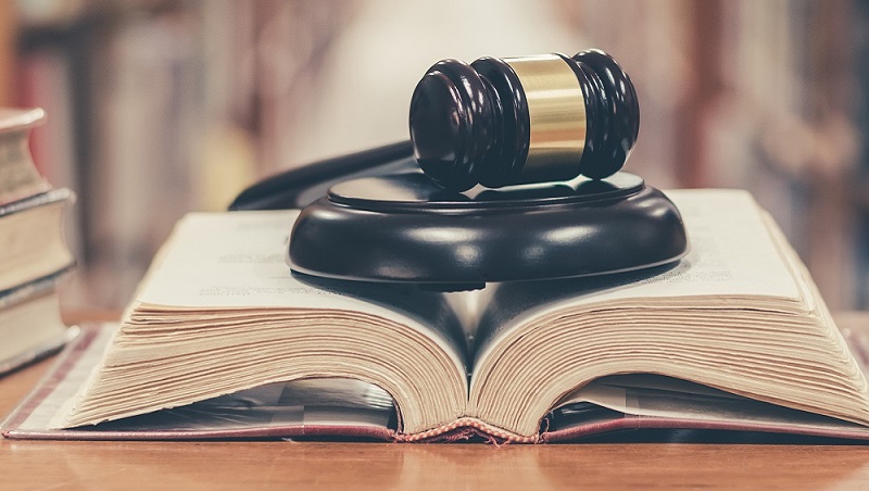 A gavel resting on top of an open book