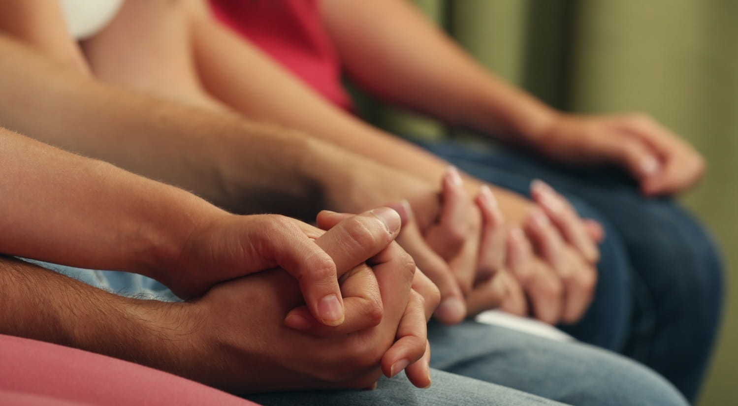 A group of adults in social care rehabilitation facilities holding hands.
