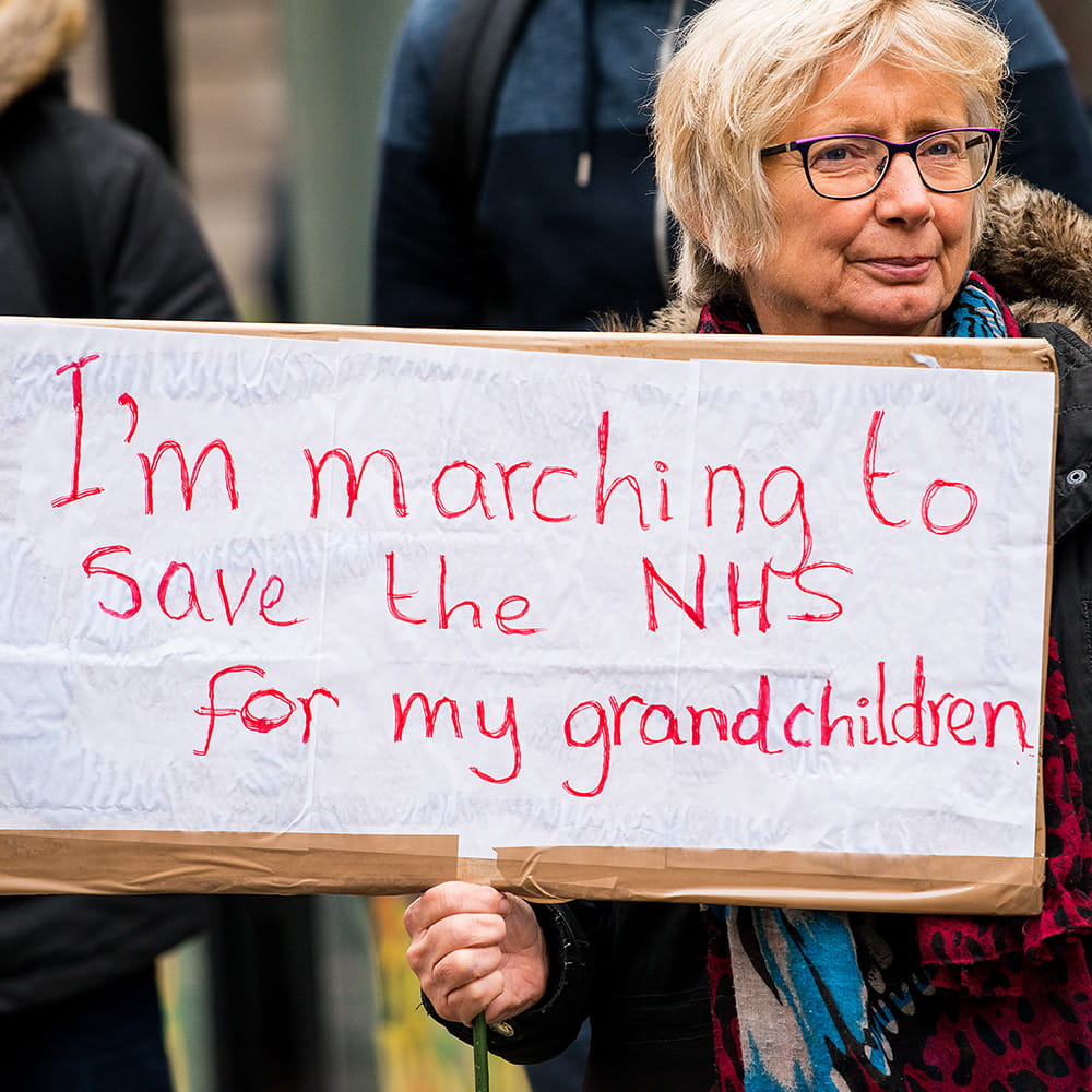Woman at a protest holding a placard 