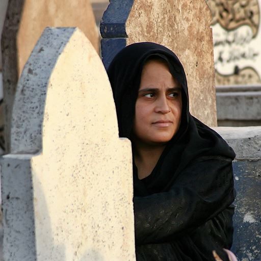Iraqi woman sitting beside a grave