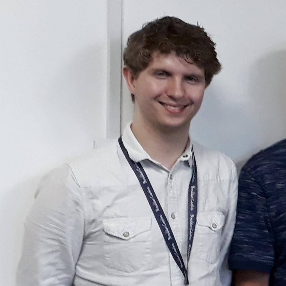 Jack wearing a white shirt and smiling for the camera.