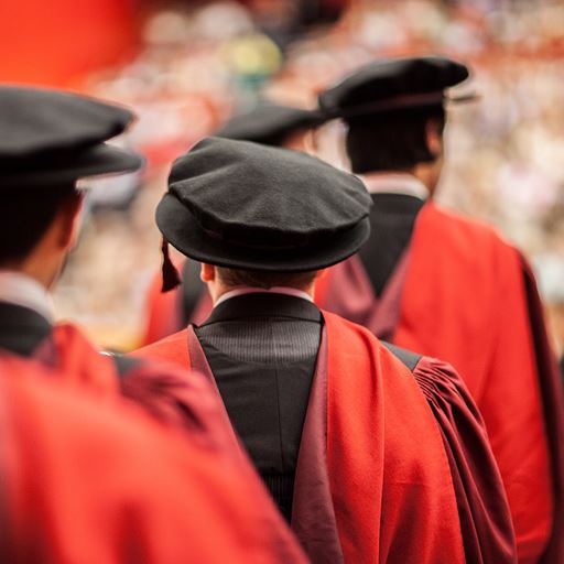 Two students wearing mortar boards at a graduation ceremony.