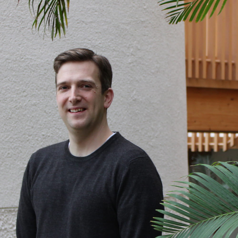 MBA Degree Apprenticeship student, Joe Chell, stands in the Essex Business School winter garden.