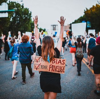 protest with sign saying your bias your privelidge