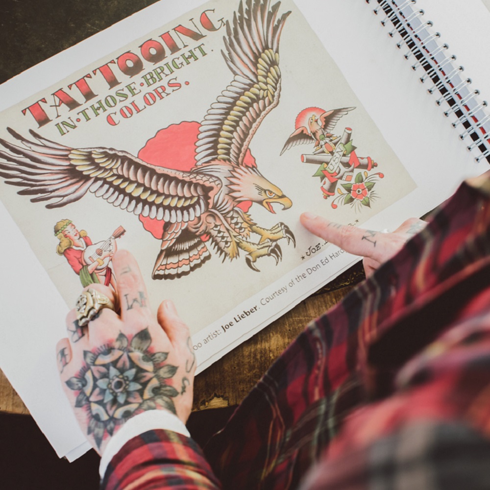Birds eye view of Matt Lodder holding tattoo book