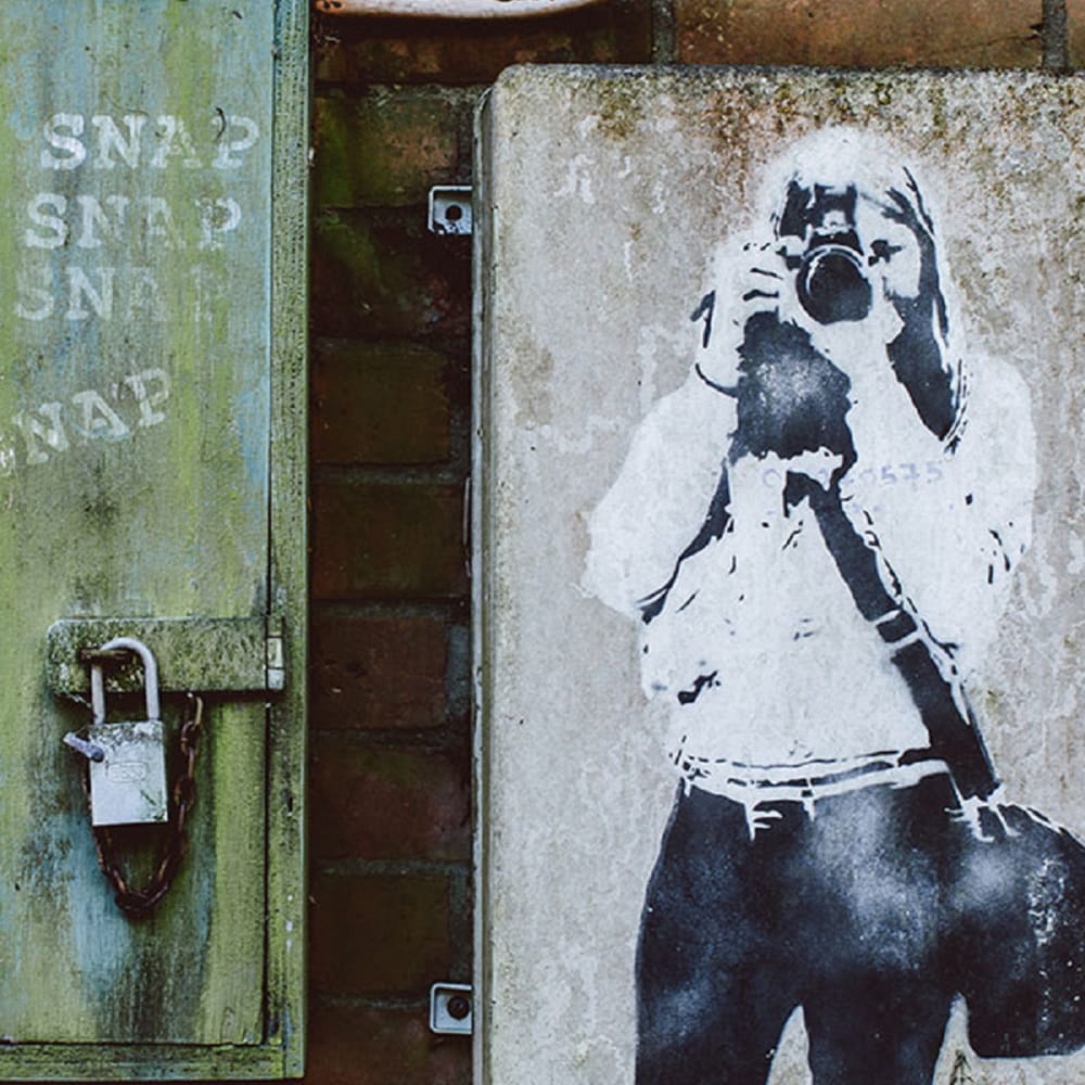A spray painting on a brick wall with a padlock on.