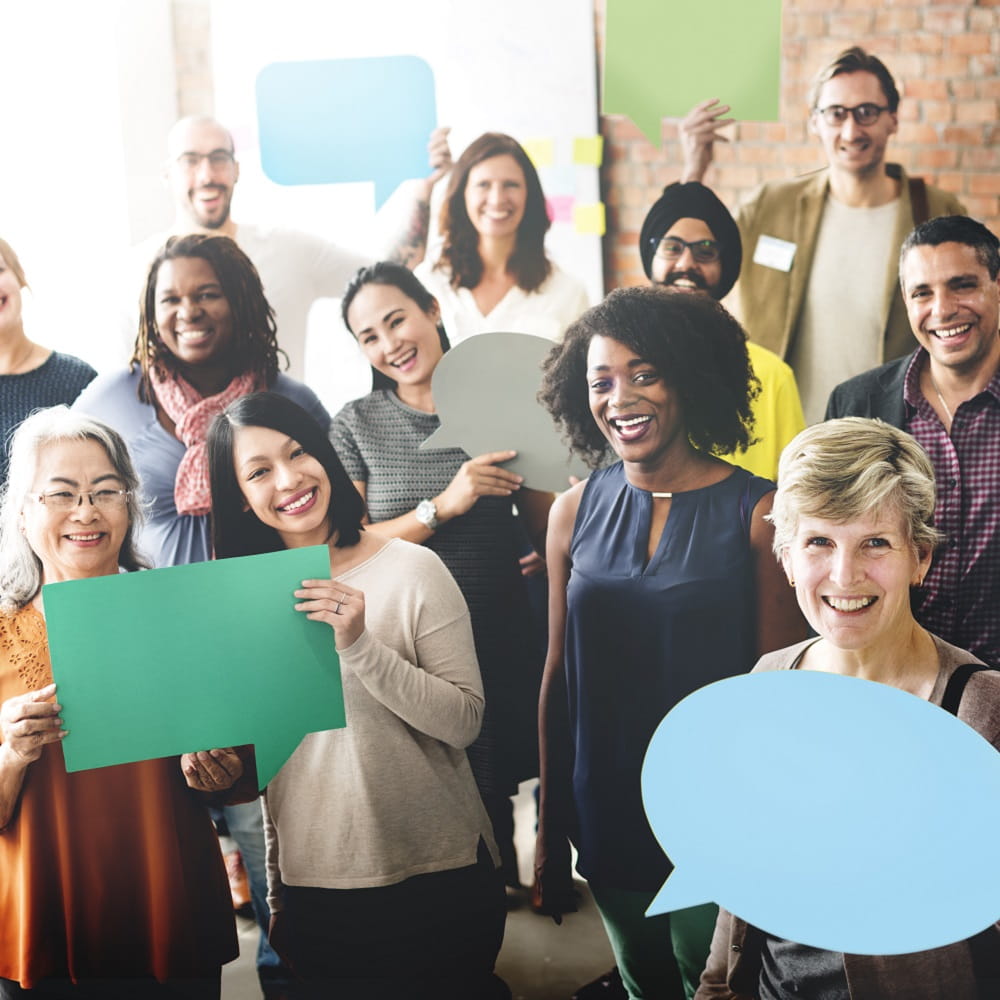 Lots of different people holding up speech bubbles.