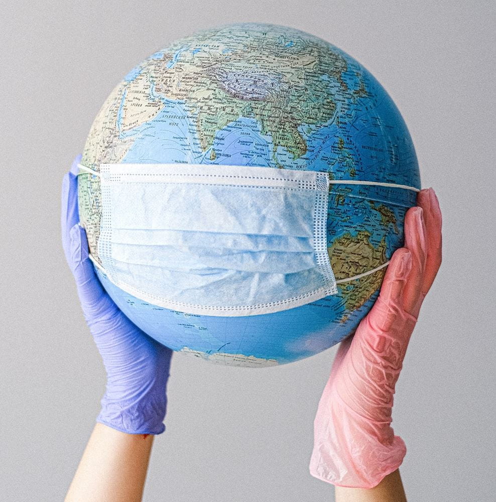 Gloved hands holding globe