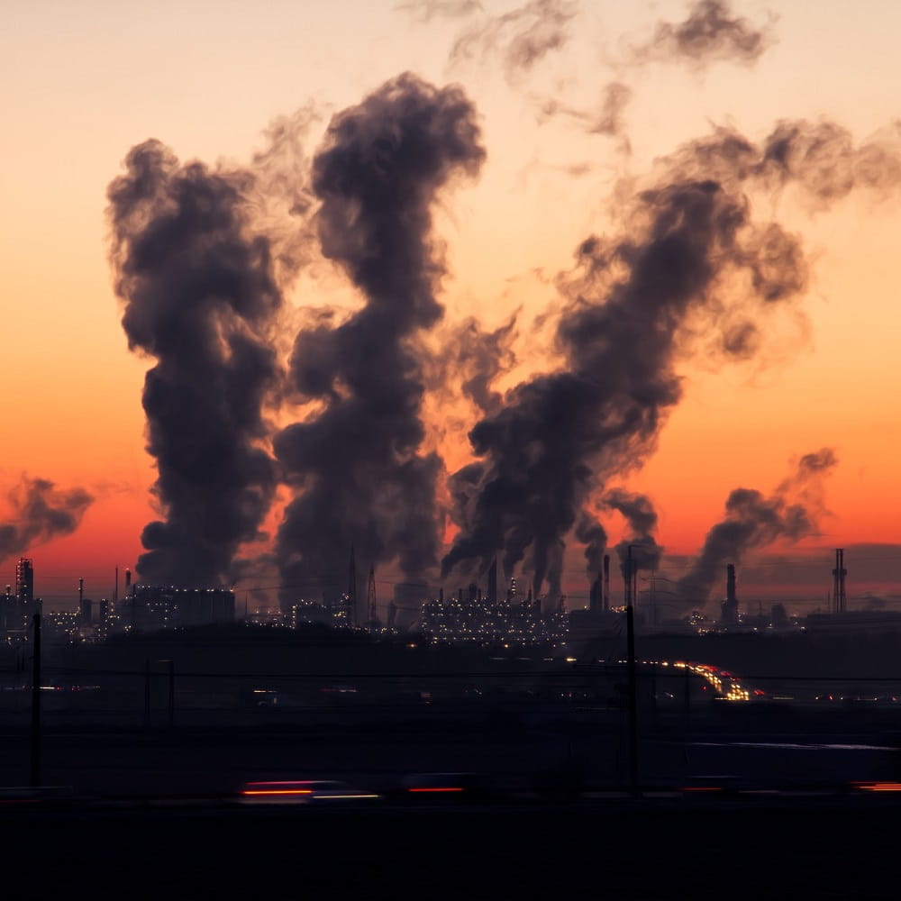 Landscape view of air pollution in front of orange sunset
