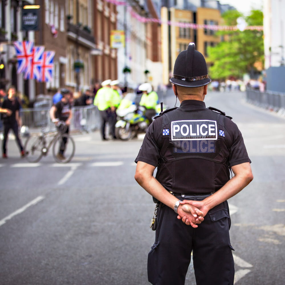 Policeman stood looking ahead at a road