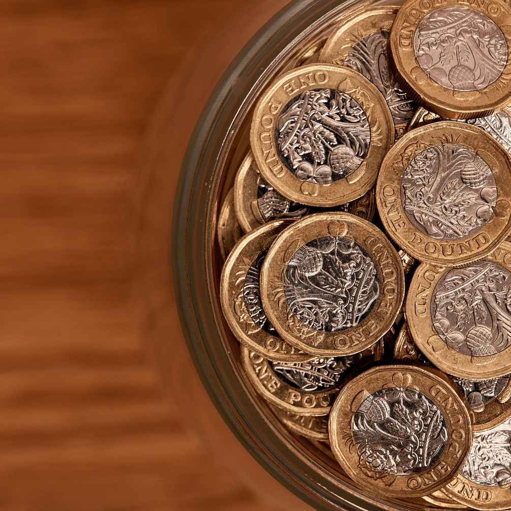 UK pound coins in a glass jar