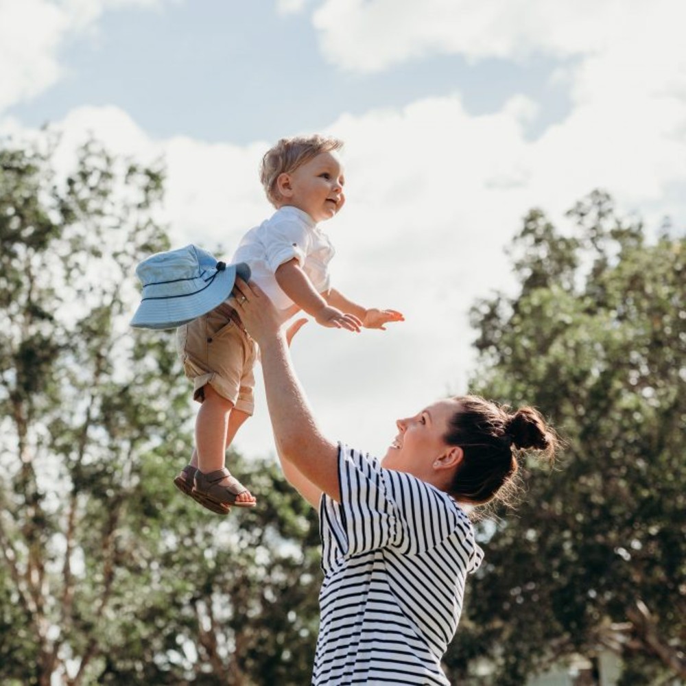 A mother holding her baby in the air
