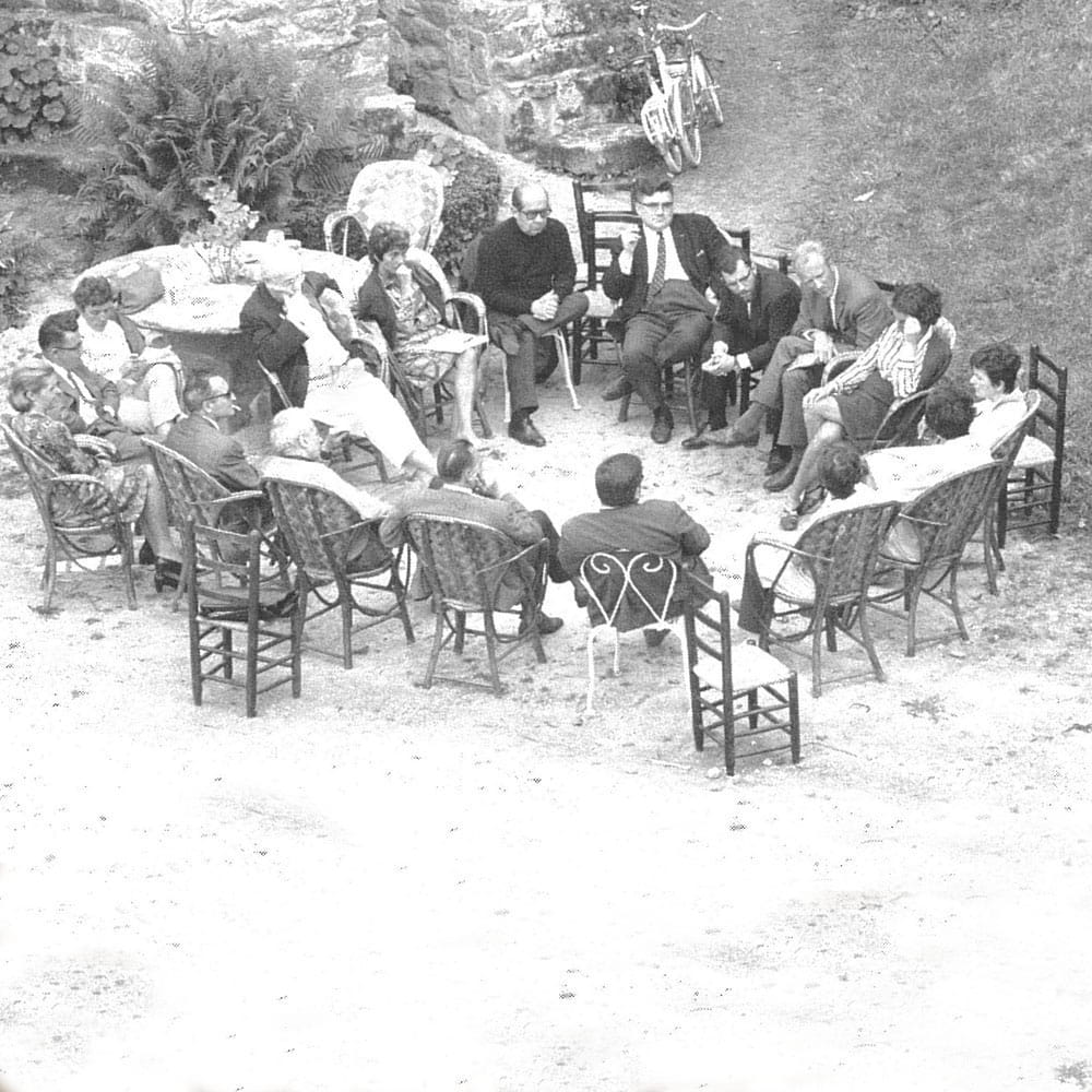 People sat in a circle outside. Black and white photo. 1968