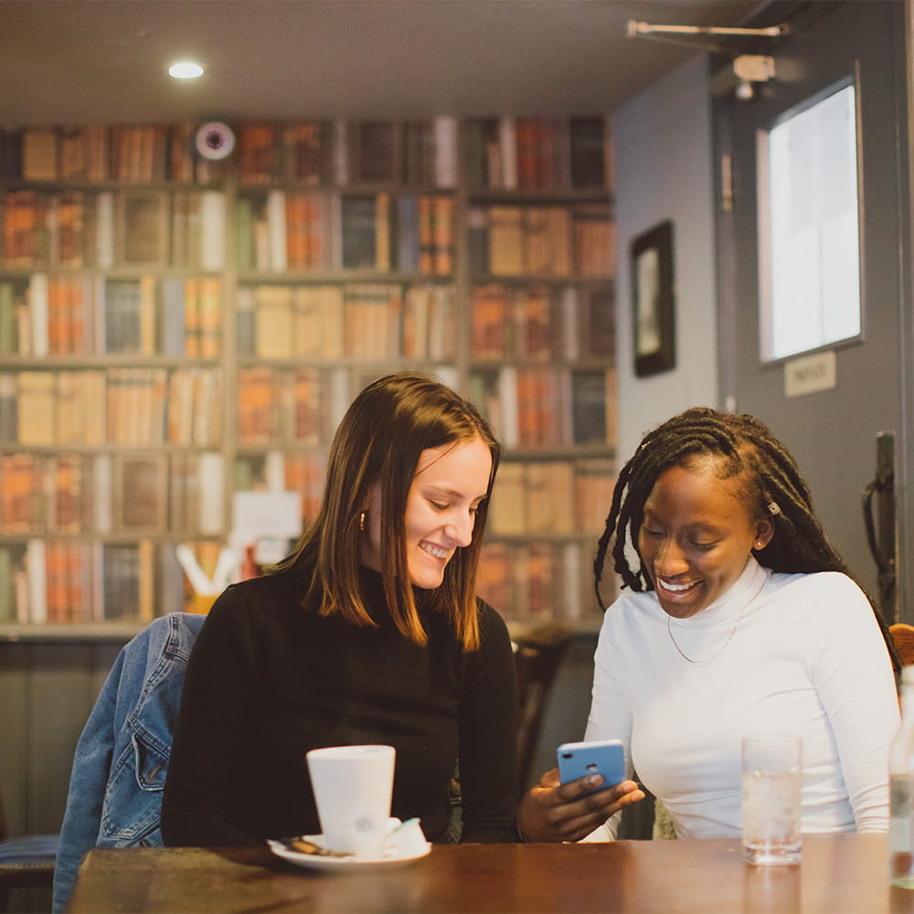 Two female students looking at a phone