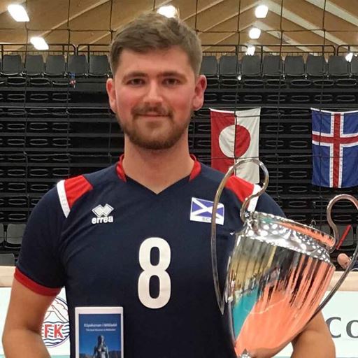Conor Walker wearing a number 8 volleyball shirt and holding a trophy 