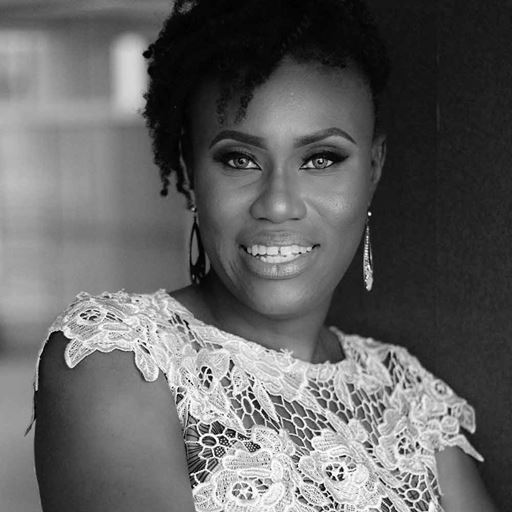 Ijeoma Okolo, photographed in black and white, wearing a lace-sleeved top 