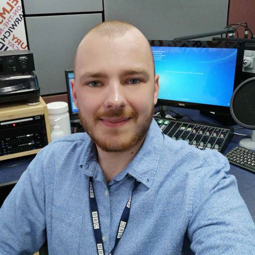 Jacob Ottaway wearing a place blue shirt and sitting in a BBC Essex newsroom