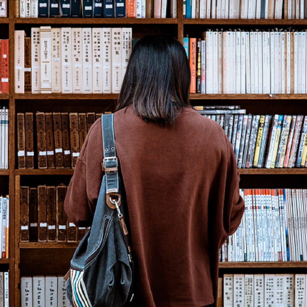 Person standing in front of bookcase