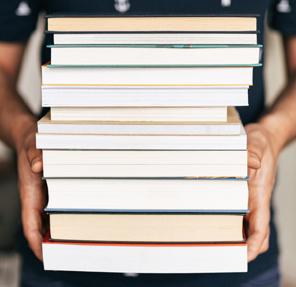 person holding stack of books