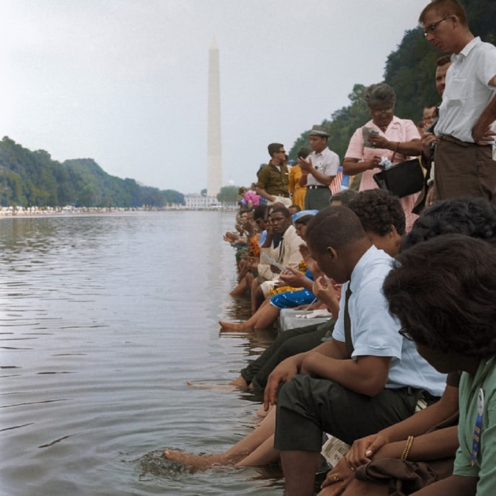 people sitting on the edge of the Lincoln Memorial Reflection Pool