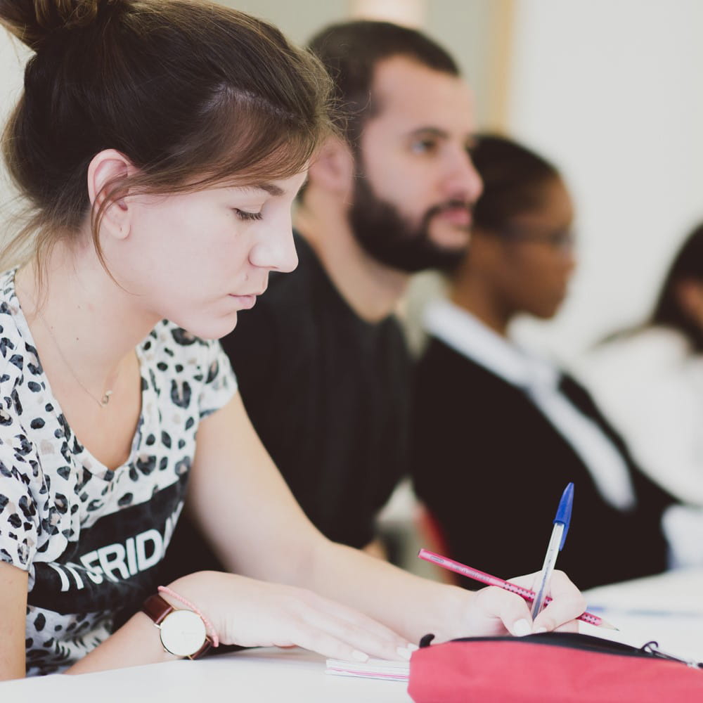 Female student sitting at desk writing