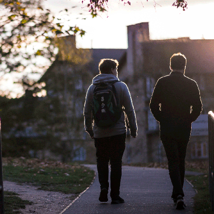 Two students walking through rural campus area