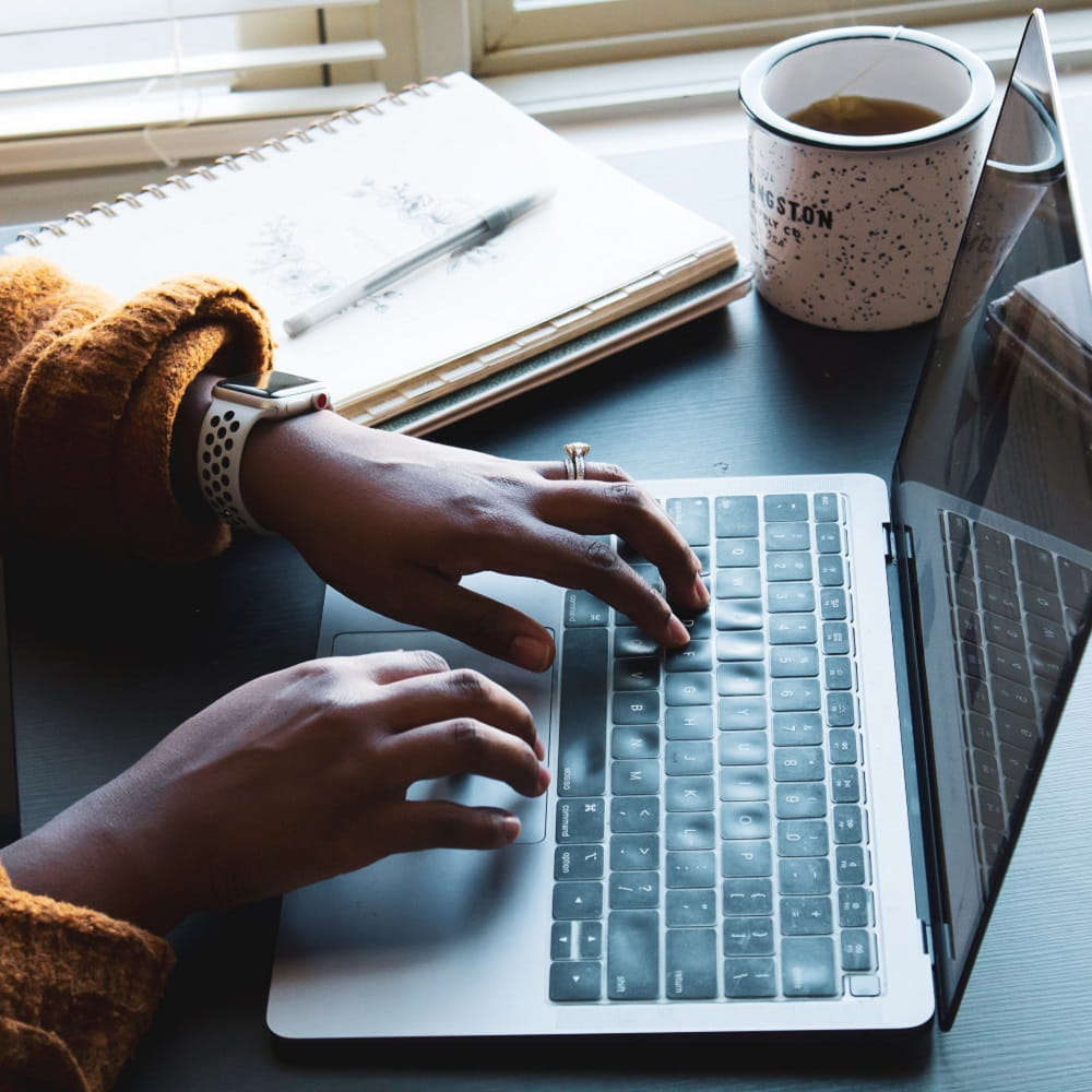 photo showing someone working at a laptop