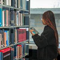 student looking for book in library