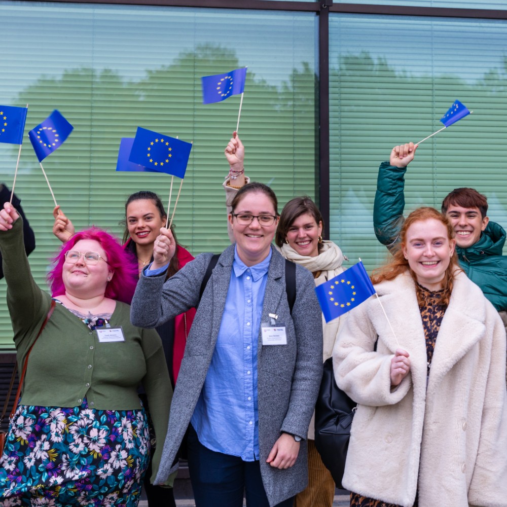 Group of YUFE students waving EU flags