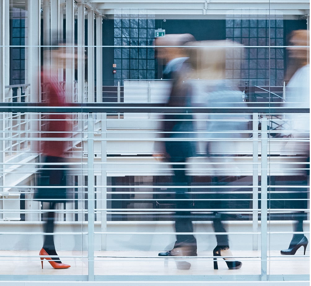 Blurred image of people walking in a corporate environment