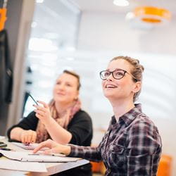 Photo of two female students in the Orangery at the Colchester Campus working together.