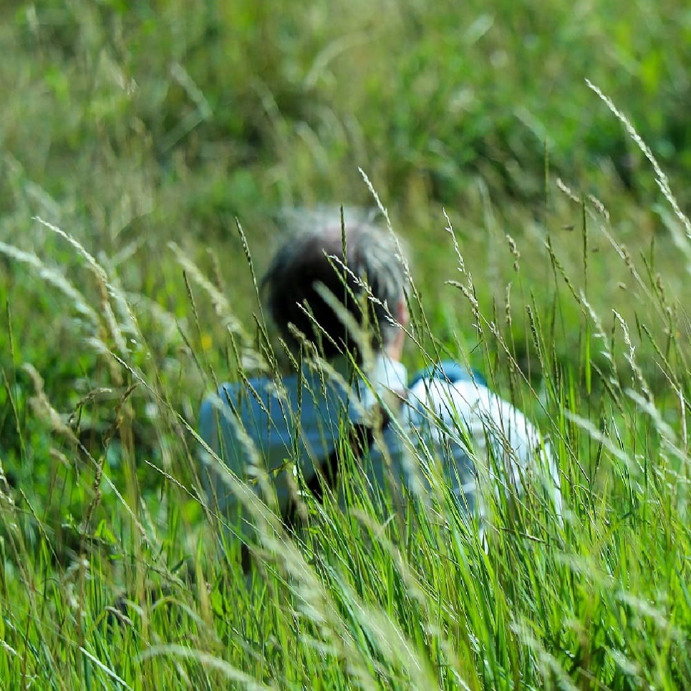 image of person sat alone in field