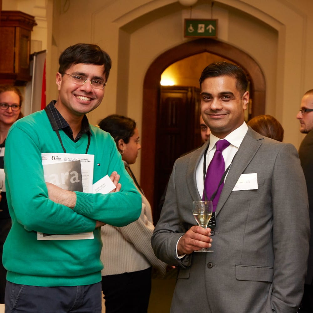 Two males stood side by side smiling