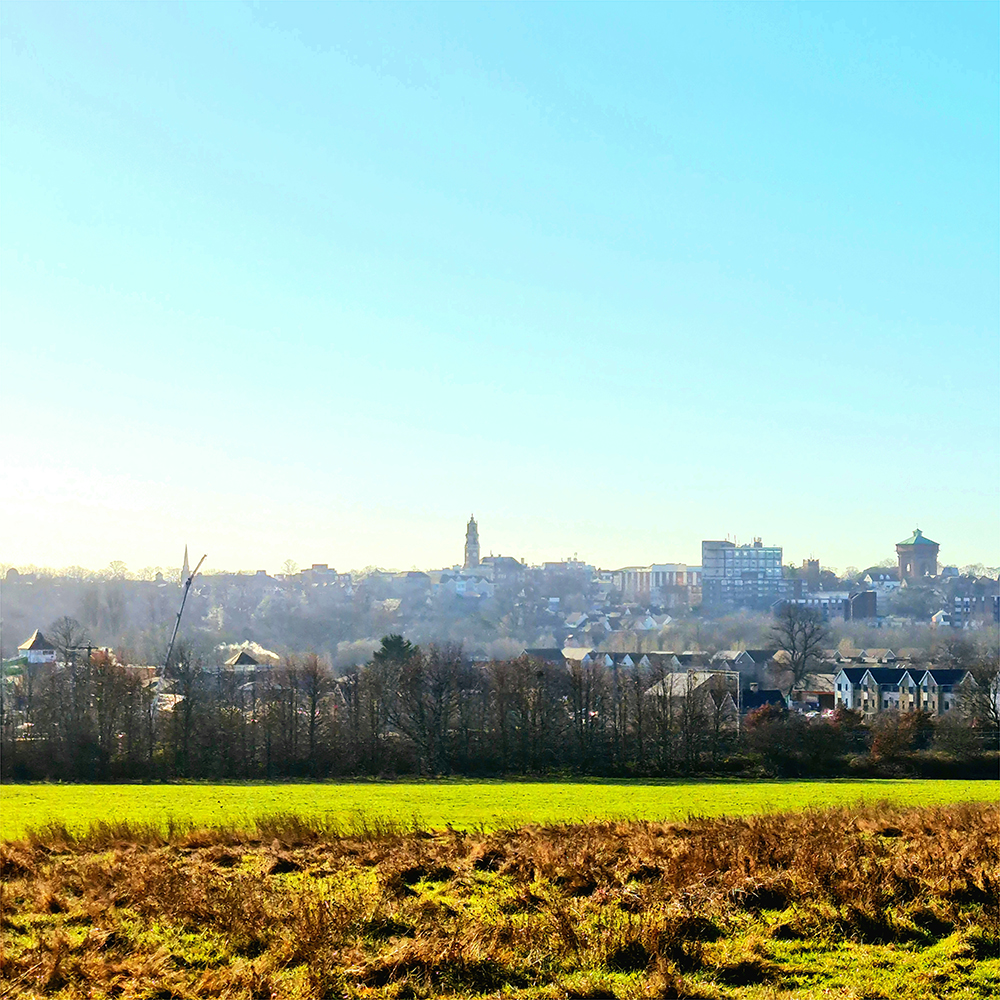 photo of town of Colchester in the distance with green fields in foreground